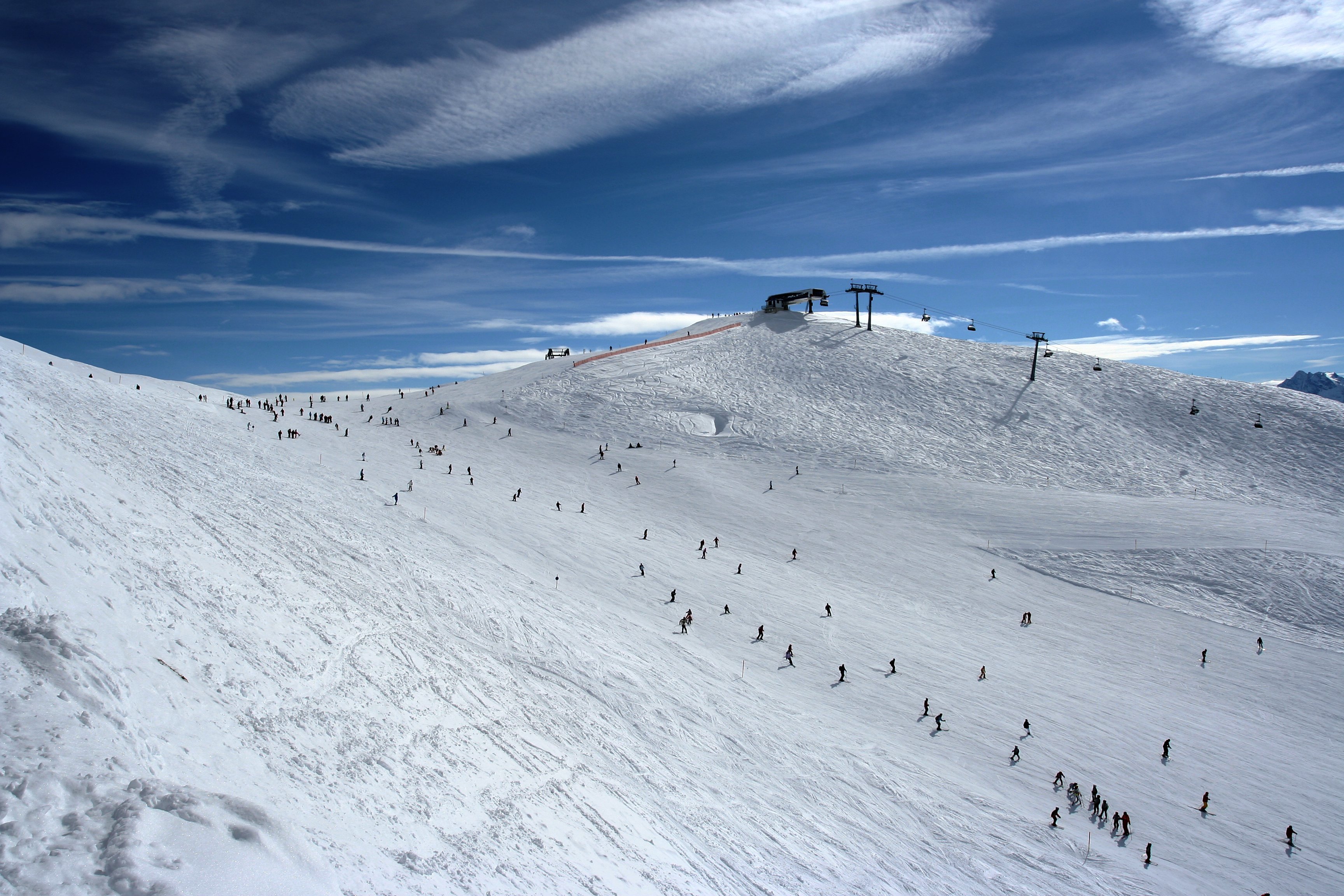 Sonnige Skipiste am Rastkogel vor den verschneiten Tiroler Bergen